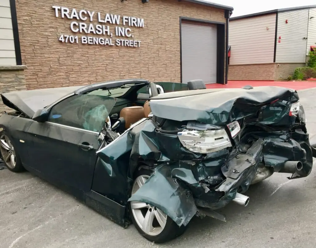 Exterior of the Tracy Law Firm\'s Dallas Crash Lab With A Newly Arrived Car That Suffered A Severe Rear End Collision That Seriously Injured the Backseat Passengers